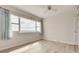 Bedroom with wood-look flooring, ceiling fan, and large windows with blue curtains at 31 Island Way # 502, Clearwater Beach, FL 33767