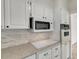 Bright kitchen features white cabinets, modern appliances, and neutral backsplash at 31 Island Way # 502, Clearwater Beach, FL 33767