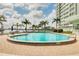 Relaxing outdoor pool surrounded by lush greenery and palm trees, offering a tranquil escape with waterfront views at 31 Island Way # 502, Clearwater Beach, FL 33767