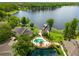 Aerial view showcases a spacious home with a pool and dock, set against a tranquil lake backdrop at 3519 Heards Ferry Dr, Tampa, FL 33618