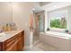 Bright bathroom with a tub, glass shower and double sink vanity, offering a relaxing retreat at 3519 Heards Ferry Dr, Tampa, FL 33618