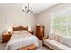 A comfortable bedroom with hardwood furniture, a ceiling fan, a couch, and a large window at 3519 Heards Ferry Dr, Tampa, FL 33618