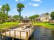 Scenic view of a wooden dock on a serene lake featuring an entertaining space with seating and shade at 3519 Heards Ferry Dr, Tampa, FL 33618