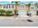 Charming townhome featuring a two-car garage, landscaped front yard, and stately palm trees at 3519 Heards Ferry Dr, Tampa, FL 33618