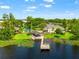 Scenic lake view featuring a wooden dock, a gazebo, and a glimpse of the inviting backyard pool area at 3519 Heards Ferry Dr, Tampa, FL 33618