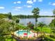 Beautiful pool area with lounge chairs, palm trees and seating overlooking a serene lake in the background at 3519 Heards Ferry Dr, Tampa, FL 33618