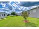 Home's exterior showcasing a green lawn, landscaping, and adjacent community structures at 37526 New Horizons Blvd, Zephyrhills, FL 33541