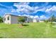 Spacious backyard featuring lush green lawn, well-kept landscaping, and community views at 37526 New Horizons Blvd, Zephyrhills, FL 33541