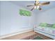 Bright bedroom with a ceiling fan, a daybed with green accents, and a patterned rug at 37526 New Horizons Blvd, Zephyrhills, FL 33541