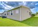 Home's exterior features well-maintained siding, efficient AC, and lush green lawn at 37526 New Horizons Blvd, Zephyrhills, FL 33541