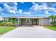 Charming home with a covered parking area and well-maintained landscaping at 37526 New Horizons Blvd, Zephyrhills, FL 33541