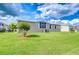 Home's exterior featuring a well-maintained lawn and efficient AC unit at 37526 New Horizons Blvd, Zephyrhills, FL 33541