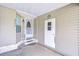 Charming front entrance with covered porch, white door, and exterior storage room at 37526 New Horizons Blvd, Zephyrhills, FL 33541