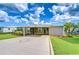 Charming single-story home with covered parking, well-manicured lawn, and tropical landscaping at 37526 New Horizons Blvd, Zephyrhills, FL 33541