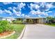 Attractive single-story residence with covered parking, complemented by lush green lawn and vibrant landscaping at 37526 New Horizons Blvd, Zephyrhills, FL 33541