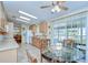 Eat-in kitchen featuring tile floors, wooden cabinets, and a glass-top table near a sliding door to a sunroom at 37526 New Horizons Blvd, Zephyrhills, FL 33541