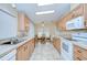 Bright kitchen featuring light wood cabinets and appliances, with an adjacent breakfast nook at 37526 New Horizons Blvd, Zephyrhills, FL 33541