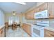 Well-lit kitchen with bright wooden cabinets and modern appliances, adjacent to a dining area at 37526 New Horizons Blvd, Zephyrhills, FL 33541