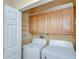 The laundry room includes a washer, dryer, cabinets and wall-mounted storage racks at 37526 New Horizons Blvd, Zephyrhills, FL 33541