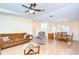 Spacious living area with cozy brown sofas, open floor plan, and access to dining room at 37526 New Horizons Blvd, Zephyrhills, FL 33541