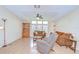 Spacious living room featuring cozy brown couches, recliner, ceiling fan, and natural light at 37526 New Horizons Blvd, Zephyrhills, FL 33541