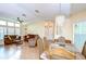 Bright living room with sofas, recliner, and a decorative chandelier over a dining table at 37526 New Horizons Blvd, Zephyrhills, FL 33541