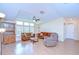 Bright living room featuring brown sofas, recliner, natural light, and ceiling fan at 37526 New Horizons Blvd, Zephyrhills, FL 33541