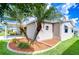 Home exterior featuring lush landscaping, palm trees, vinyl siding, and a serene outdoor setting at 37526 New Horizons Blvd, Zephyrhills, FL 33541