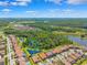 Community aerial view showcases a scenic pond, mature trees, and residential neighborhood at 3999 Burdick Loop, Odessa, FL 33556