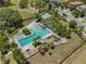 Aerial view of the luxurious community pool with ample seating, umbrellas, and lush landscaping at 3999 Burdick Loop, Odessa, FL 33556