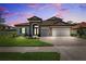 Charming two-story home featuring manicured lawn, brick driveway, and integrated two-car garage at 3999 Burdick Loop, Odessa, FL 33556