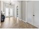 Bright foyer featuring herringbone-patterned tile floors, a black console table, and decorative frosted glass double-door entrance at 3999 Burdick Loop, Odessa, FL 33556