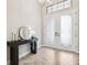 Bright foyer featuring herringbone-patterned tile floors, a black console table, and decorative frosted glass double-door entrance at 3999 Burdick Loop, Odessa, FL 33556