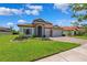 Beautiful front exterior features a three-car garage and tiled roof, situated on a well-manicured lawn at 3999 Burdick Loop, Odessa, FL 33556