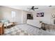 Stylish living room featuring a ceiling fan, gray carpet, TV and beach-themed artwork at 3999 Burdick Loop, Odessa, FL 33556