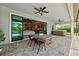 Outdoor patio featuring a dining area, fan, and access to the hot tub and indoor living area at 3999 Burdick Loop, Odessa, FL 33556