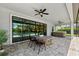 Covered patio features stone floors, modern ceiling fans, a hot tub, and sliding glass doors to the outdoor pool at 3999 Burdick Loop, Odessa, FL 33556
