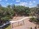 Aerial view of a neighborhood playground, surrounded by trees and featuring various play structures under a bright blue sky at 3999 Burdick Loop, Odessa, FL 33556