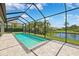 Screened pool with clear water overlooks a fenced backyard with a serene view of the adjacent pond at 3999 Burdick Loop, Odessa, FL 33556