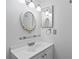 Bathroom with a white single sink vanity, decorative mirror, and modern lighting at 441 75Th N Ave, St Petersburg, FL 33702