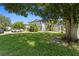 Well-maintained exterior with lush greenery and convenient parking, all under the shade of a mature tree at 441 75Th N Ave, St Petersburg, FL 33702
