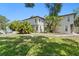 Exterior view showcasing lush landscaping, well-maintained lawn, and ample parking spaces for residents at 441 75Th N Ave, St Petersburg, FL 33702