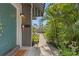 A teal door welcomes you, complemented by lush tropical landscaping, marking the inviting entrance to the home at 441 75Th N Ave, St Petersburg, FL 33702