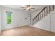 Bright living room featuring wood-look floors, a staircase, and a large window providing natural light at 441 75Th N Ave, St Petersburg, FL 33702