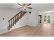 Spacious living room with wood-look floors and a staircase and a view into the kitchen with a glass chandelier at 441 75Th N Ave, St Petersburg, FL 33702