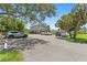 Exterior of a well-maintained home with parking spaces, lush greenery, and mature trees at 441 75Th N Ave, St Petersburg, FL 33702