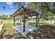 Backyard wooden pergola structure on a concrete pad with mature trees and surrounding privacy fence at 4461 Shore Acres Ne Blvd, St Petersburg, FL 33703