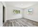 Bright bedroom with natural light, two windows, and modern gray wood-look floors at 4461 Shore Acres Ne Blvd, St Petersburg, FL 33703