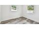 Cozy bedroom with natural light, two windows, and modern gray wood-look floors at 4461 Shore Acres Ne Blvd, St Petersburg, FL 33703
