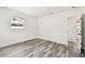 Bright bedroom with wood-look flooring and white trim; bathroom access visible through open door at 4461 Shore Acres Ne Blvd, St Petersburg, FL 33703